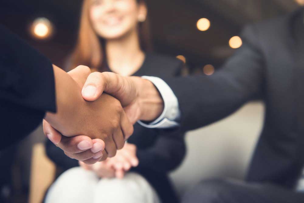 Two people shaking hands, representing partnership with First Nations businesses